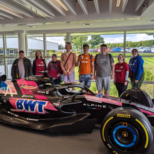 Eight people behind a Formula One car
