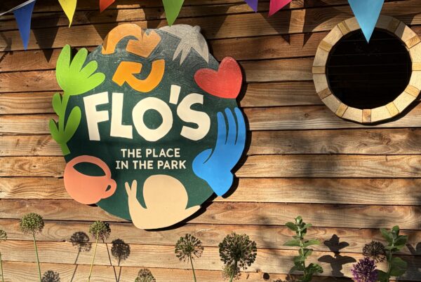 Flo's Hatch outdoor café kiosk at Flo's Place in the Park, Florence Park, with bunting, garden planting and a lunch table in the foreground.